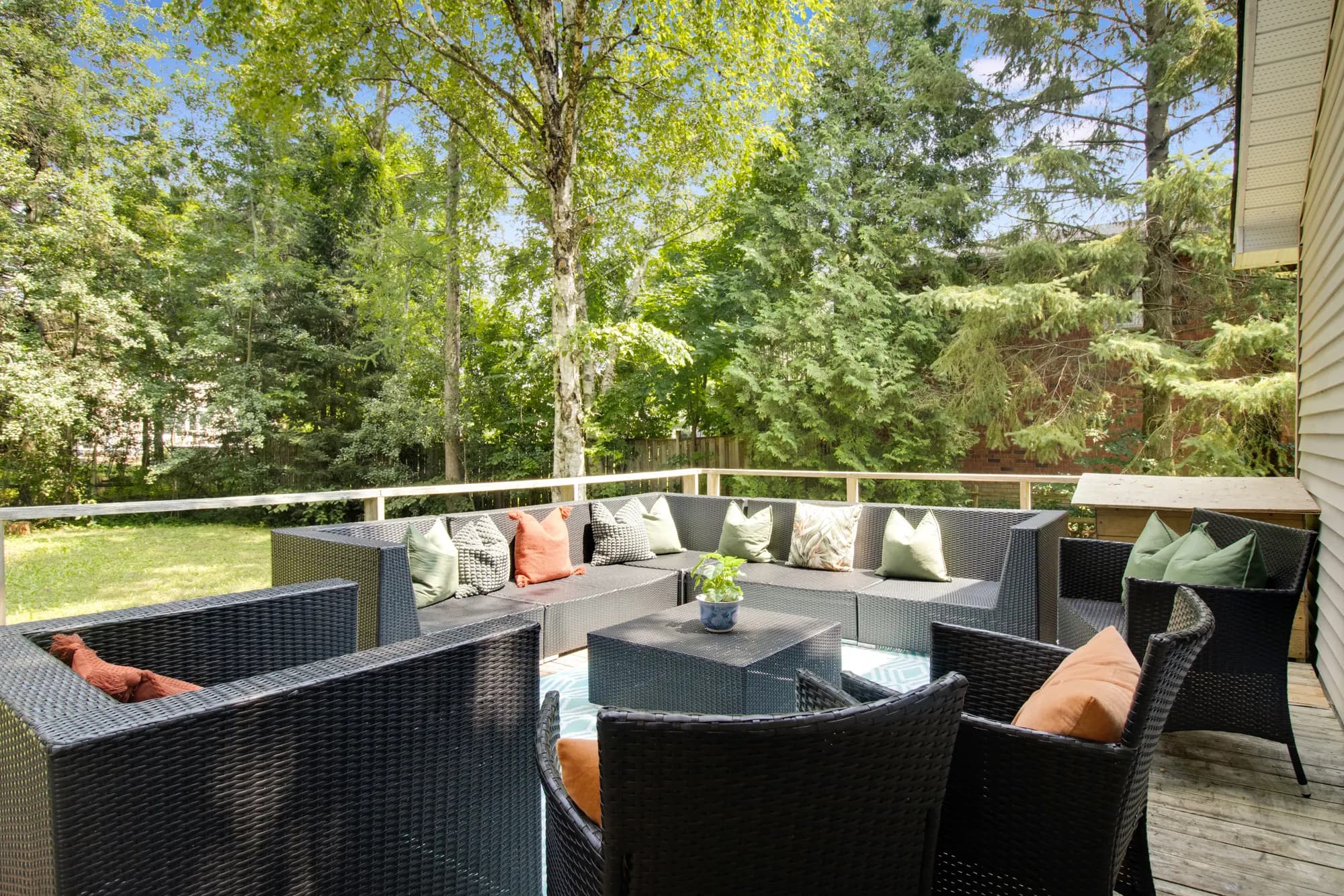 Covered deck seating with cushions, looking out into the trees