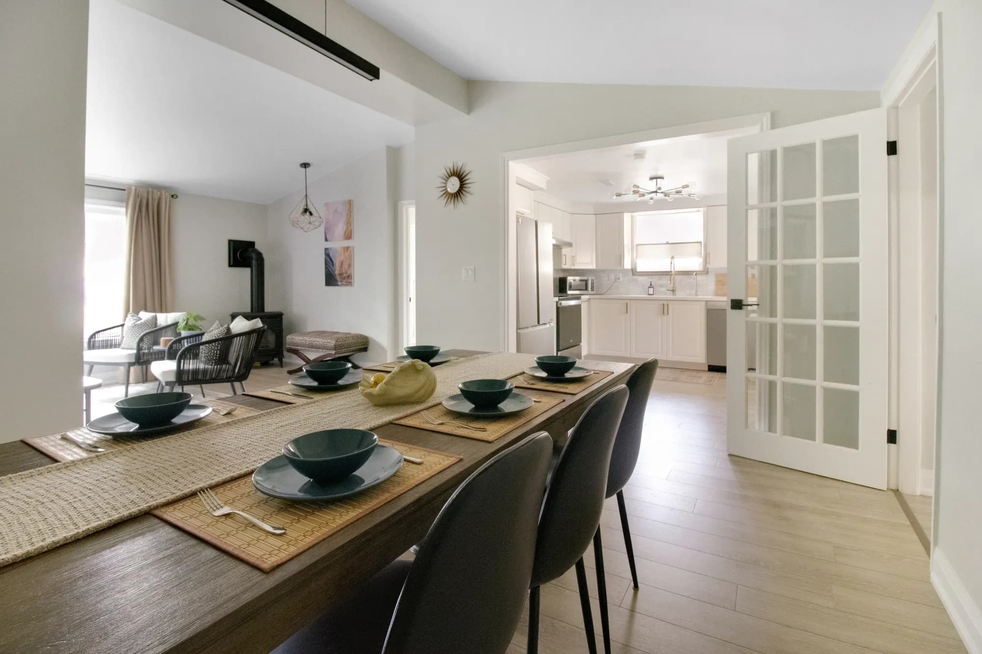 The dining table laid for a meal, with the kitchen beyond